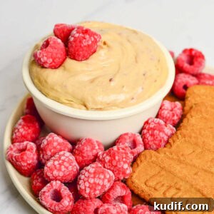 Raspberry Cookie Butter Dip Recipe: Sweet Fruit & Spread Dessert Dip 6 Small bowl of cookie butter dip on a plate with raspberries and Lotus cookies.