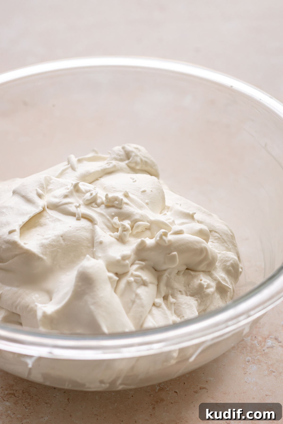 Coconut Tres Leches Cake Recipe — Moist Latin-Style Dessert 14 Whipped cream in a bowl.