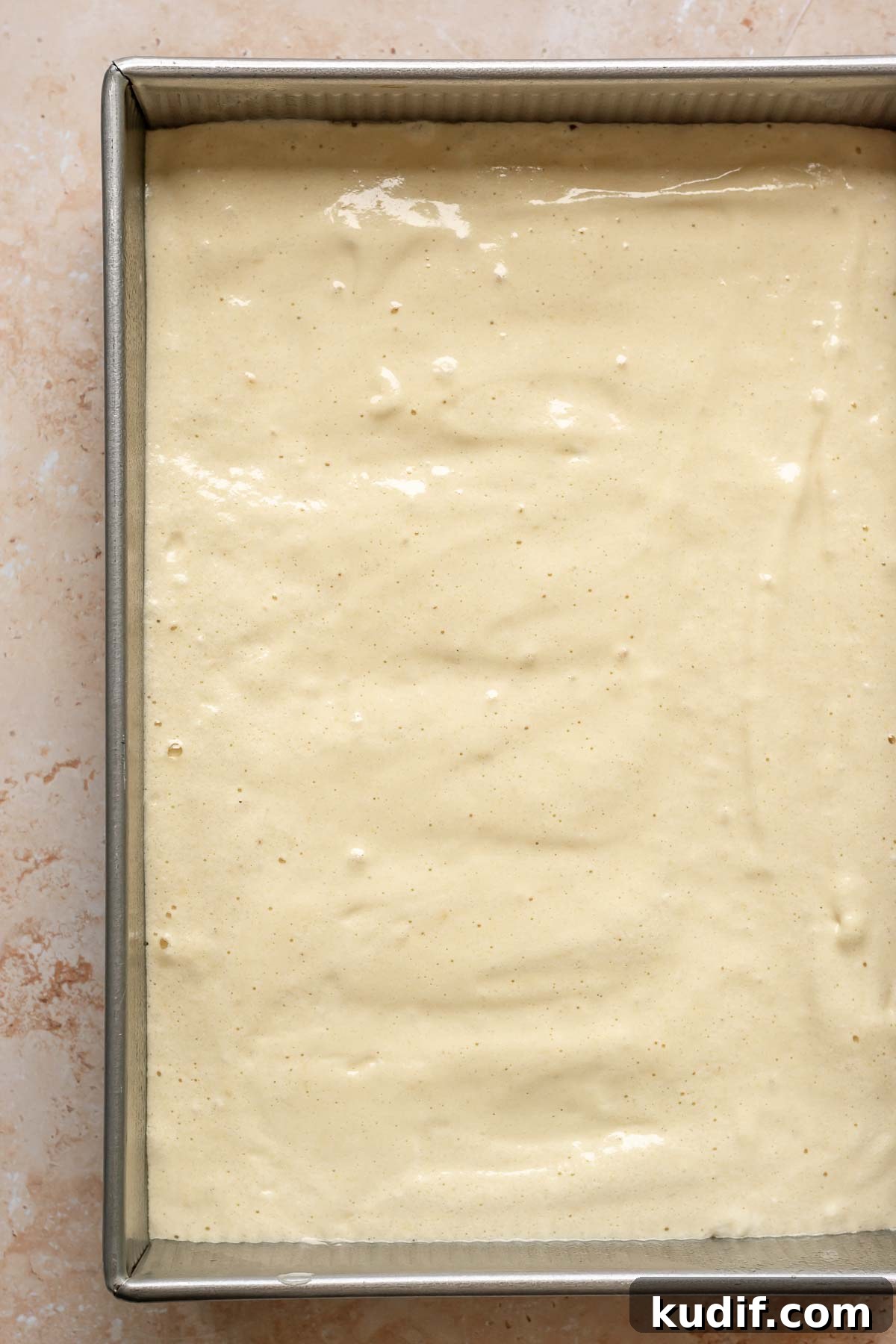 Coconut Tres Leches Cake Recipe — Moist Latin-Style Dessert 10 Sponge cake batter in a 9x13 inch pan.
