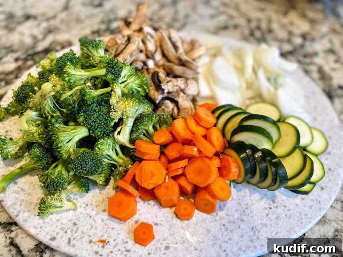 Cut broccoli, mushrooms, white onions, zucchini and carrots.