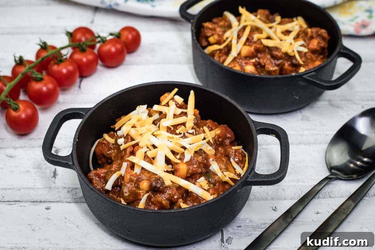 31 Delicious Recipes That Deliver Big Flavor with Little Effort 13 Two black pots of Slow Cooker Southwestern Chili topped with shredded cheese.