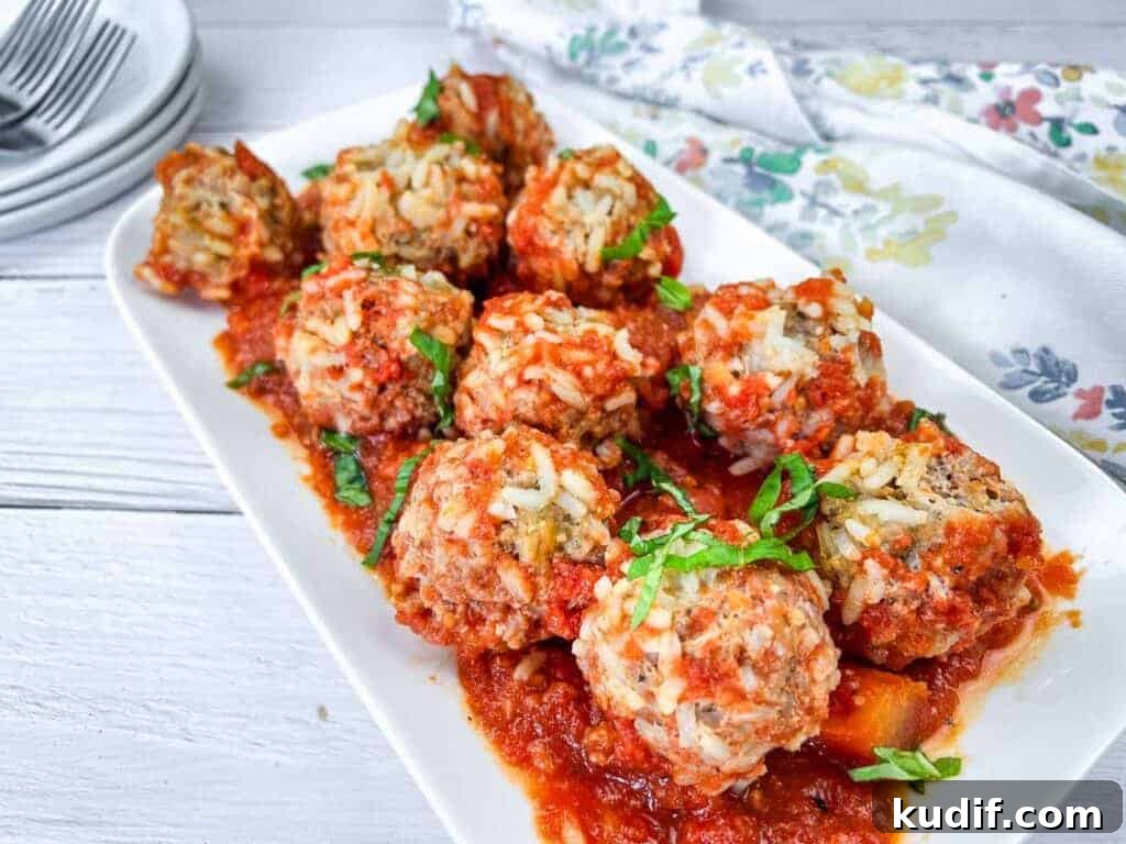 31 Delicious Recipes That Deliver Big Flavor with Little Effort 31 A white rectangular plate with slow cooker porcupine meatballs, garnished with fresh herbs.