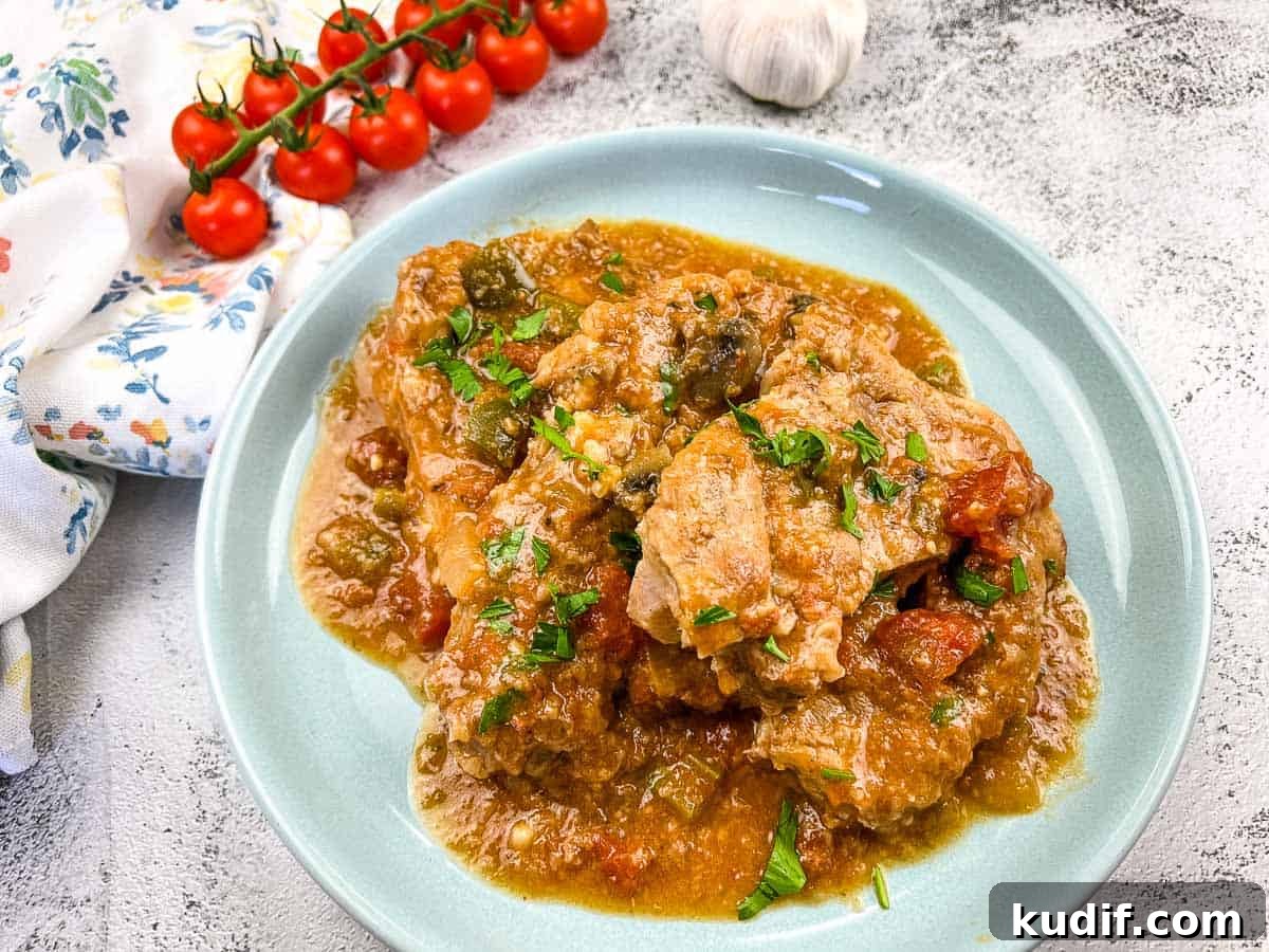 31 Delicious Recipes That Deliver Big Flavor with Little Effort 10 Slow Cooker Swiss Pork Chops on a baby blue serving dish.
