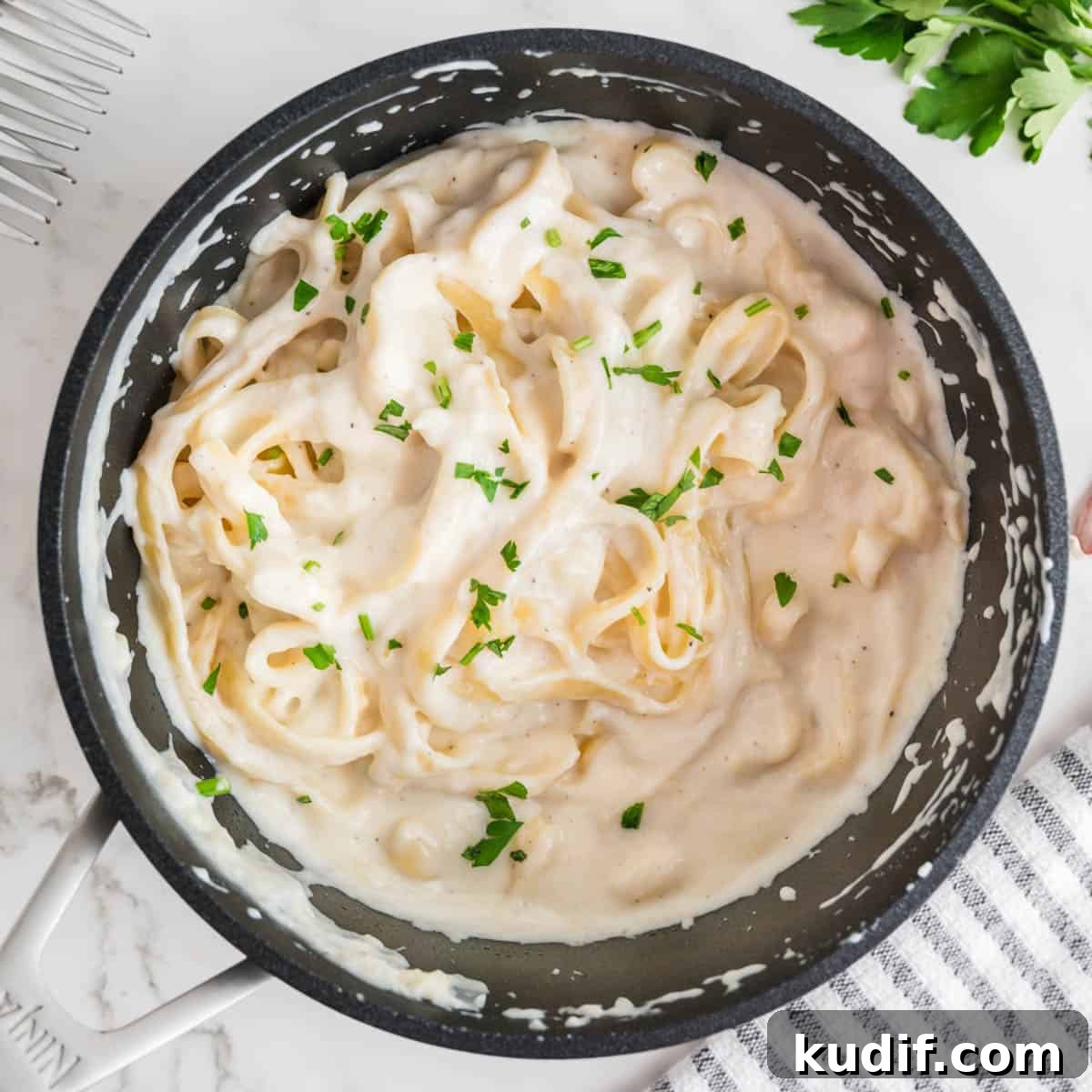 Creamy Homemade Alfredo Sauce Using Milk — Simple Recipe 12 Pasta in a sauce in a black pot.