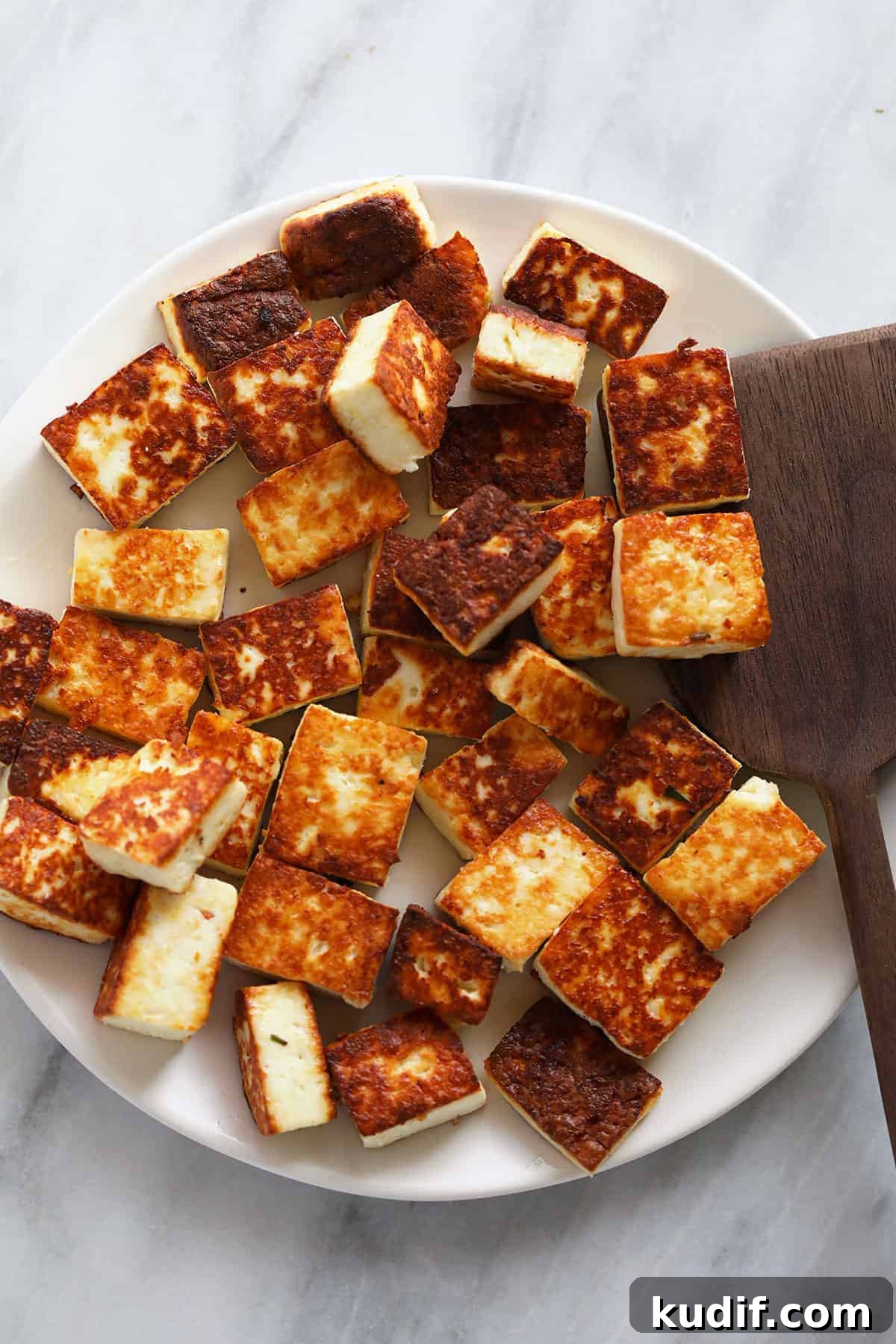 Browned paneer on a plate. 