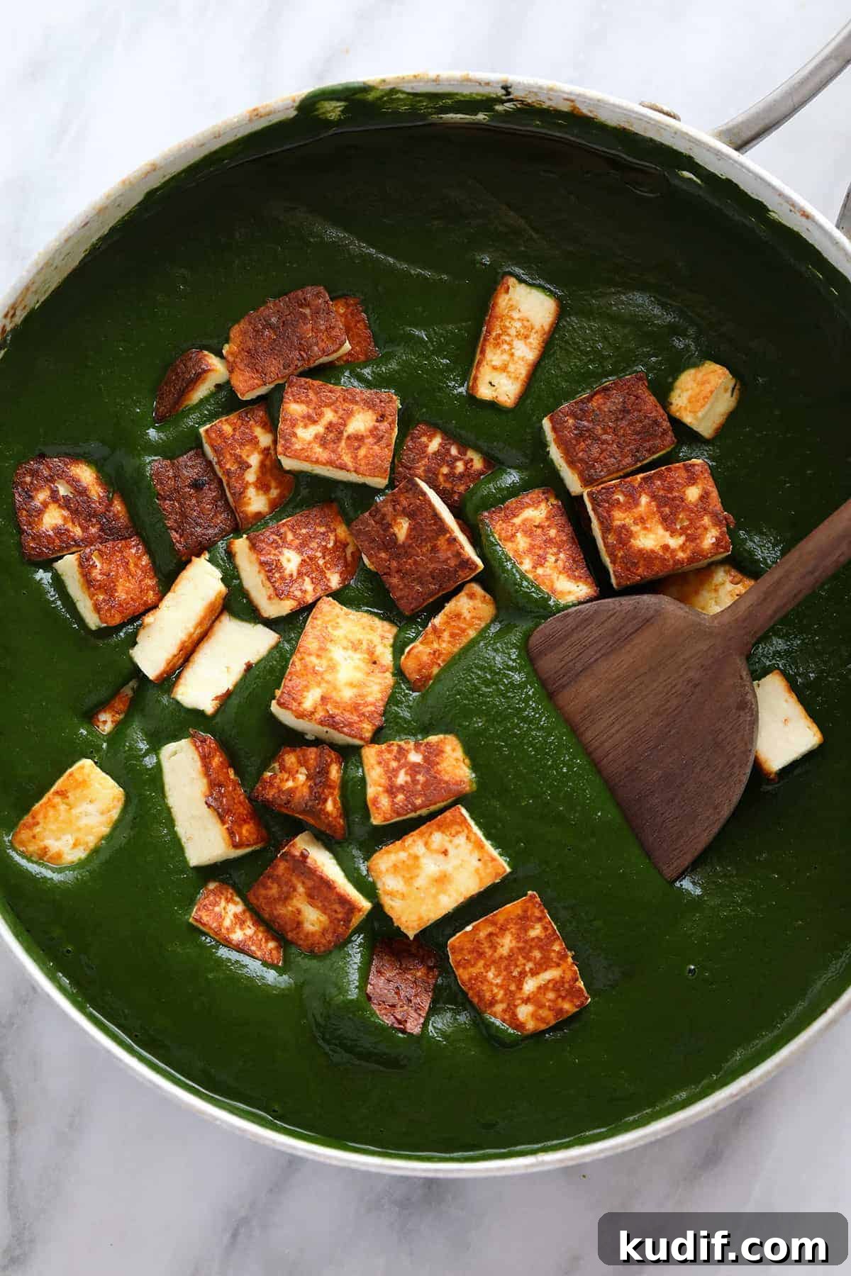 Paneer added to curry sauce. 