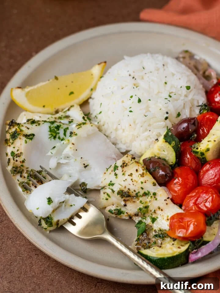 Mediterranean Sheet-Pan Baked Cod with Parsley Garlic Oil 12 bite of flaky fish on a fork