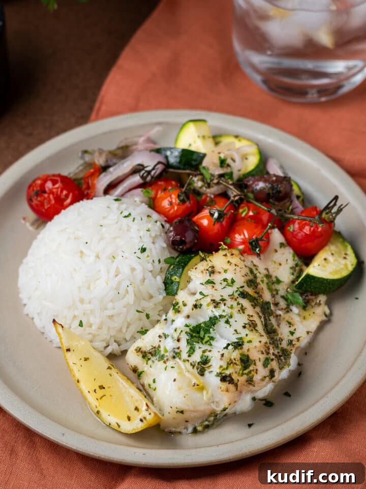 Mediterranean Sheet-Pan Baked Cod with Parsley Garlic Oil 4 mediterranean baked cod on a plate with rice and veggies