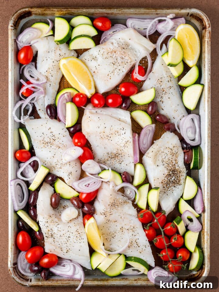 Mediterranean Sheet-Pan Baked Cod with Parsley Garlic Oil 6 cherry tomatoes, zucchini, shallot and lemons added to the pan with the cod