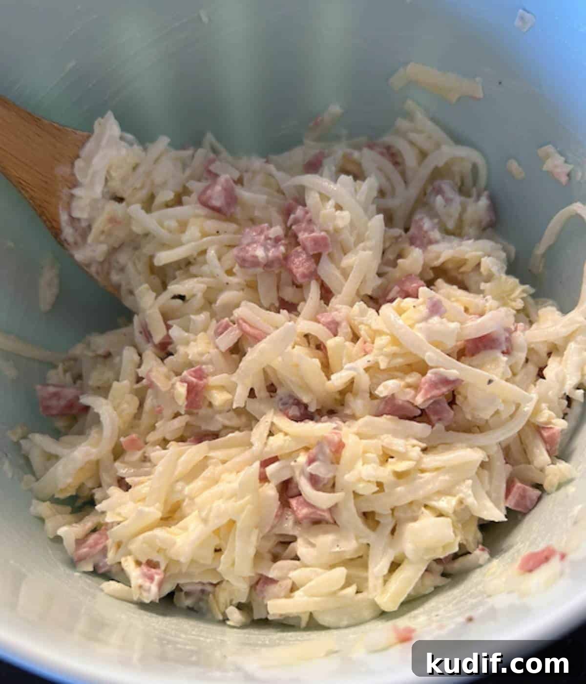 Cheesy Ham, Egg & Hashbrown Breakfast Casserole Recipe 4 Casserole ingredients in a bowl with wooden spoon.