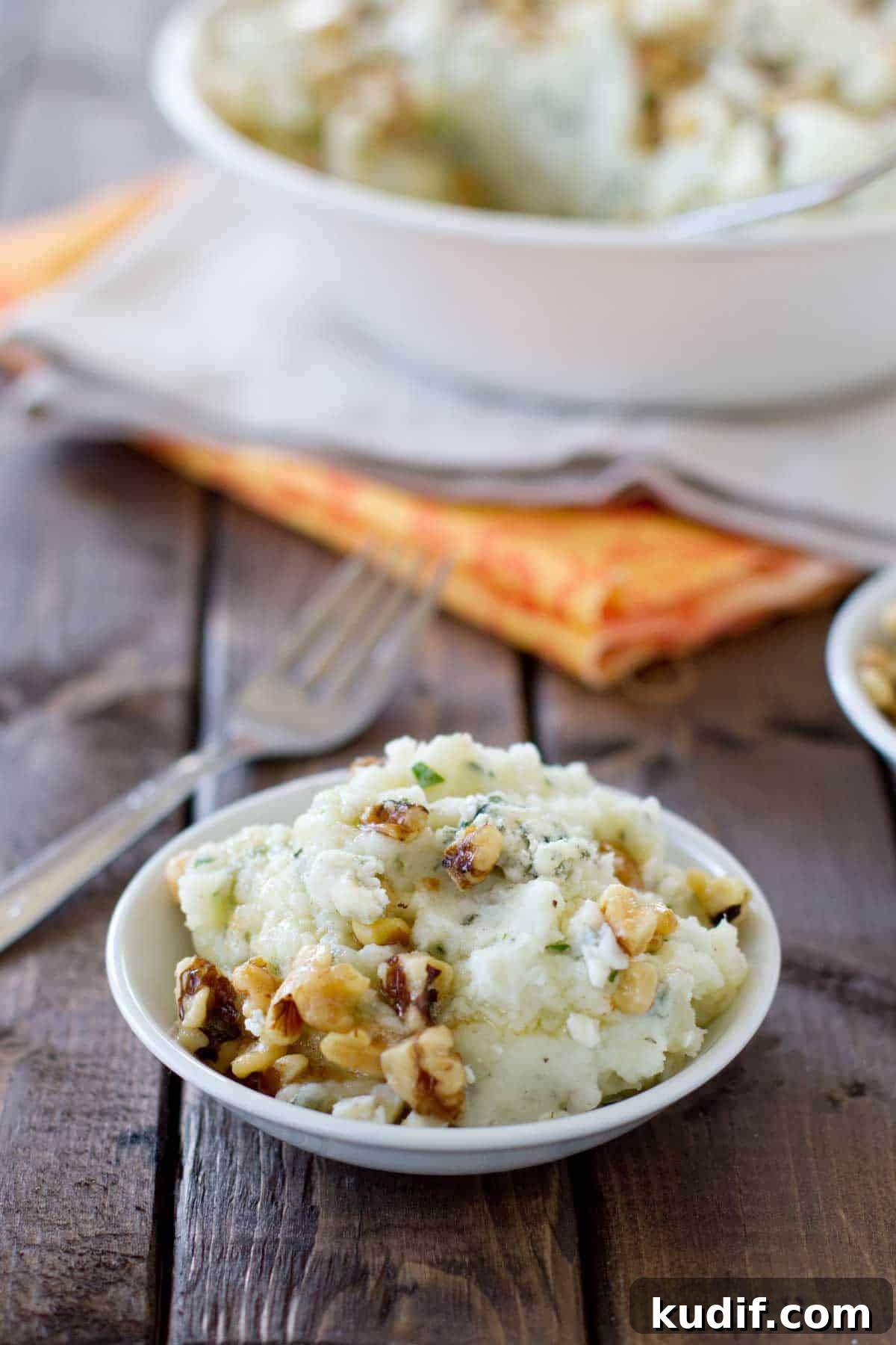 Small shallow bowl filled with Blue Cheese and Walnut Mashed Potatoes.