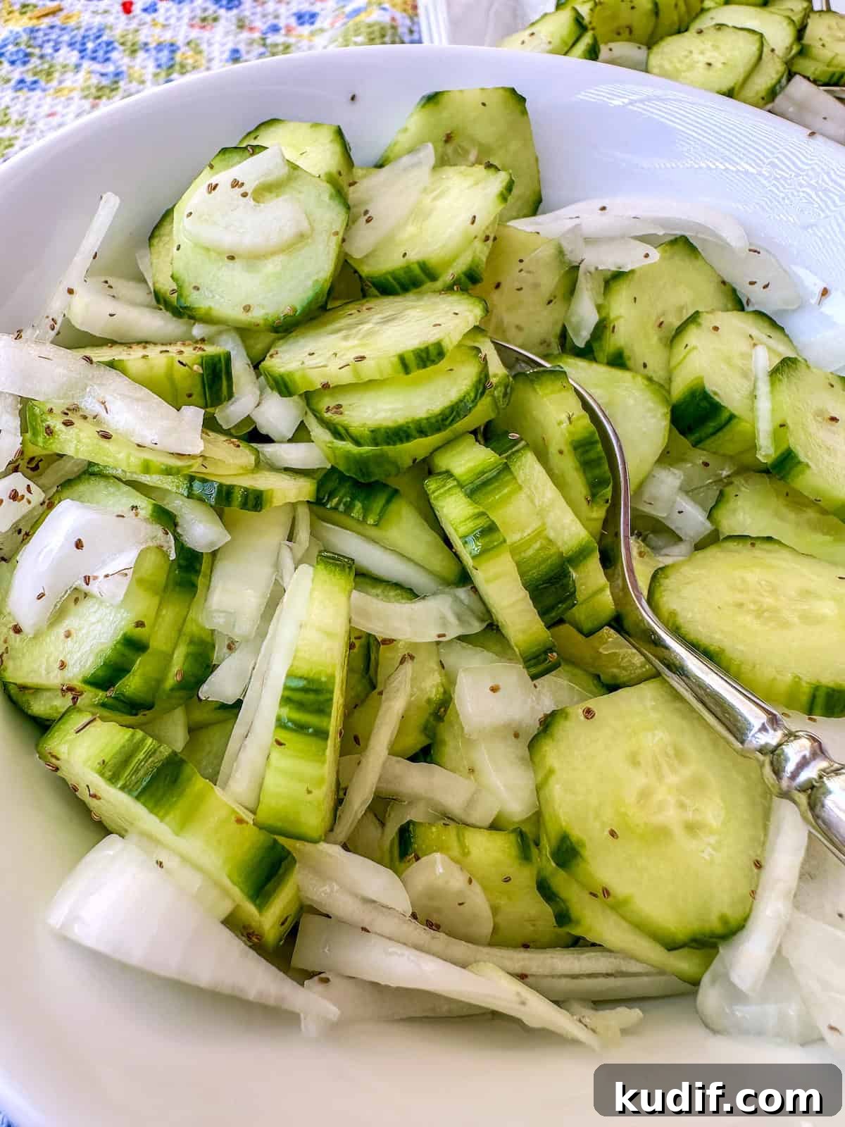 Crisp Quick Pickled Cucumbers Recipe for Homemade Snacks 2 A bowl of quick pickled cucumbers with sliced onions in a bowl.