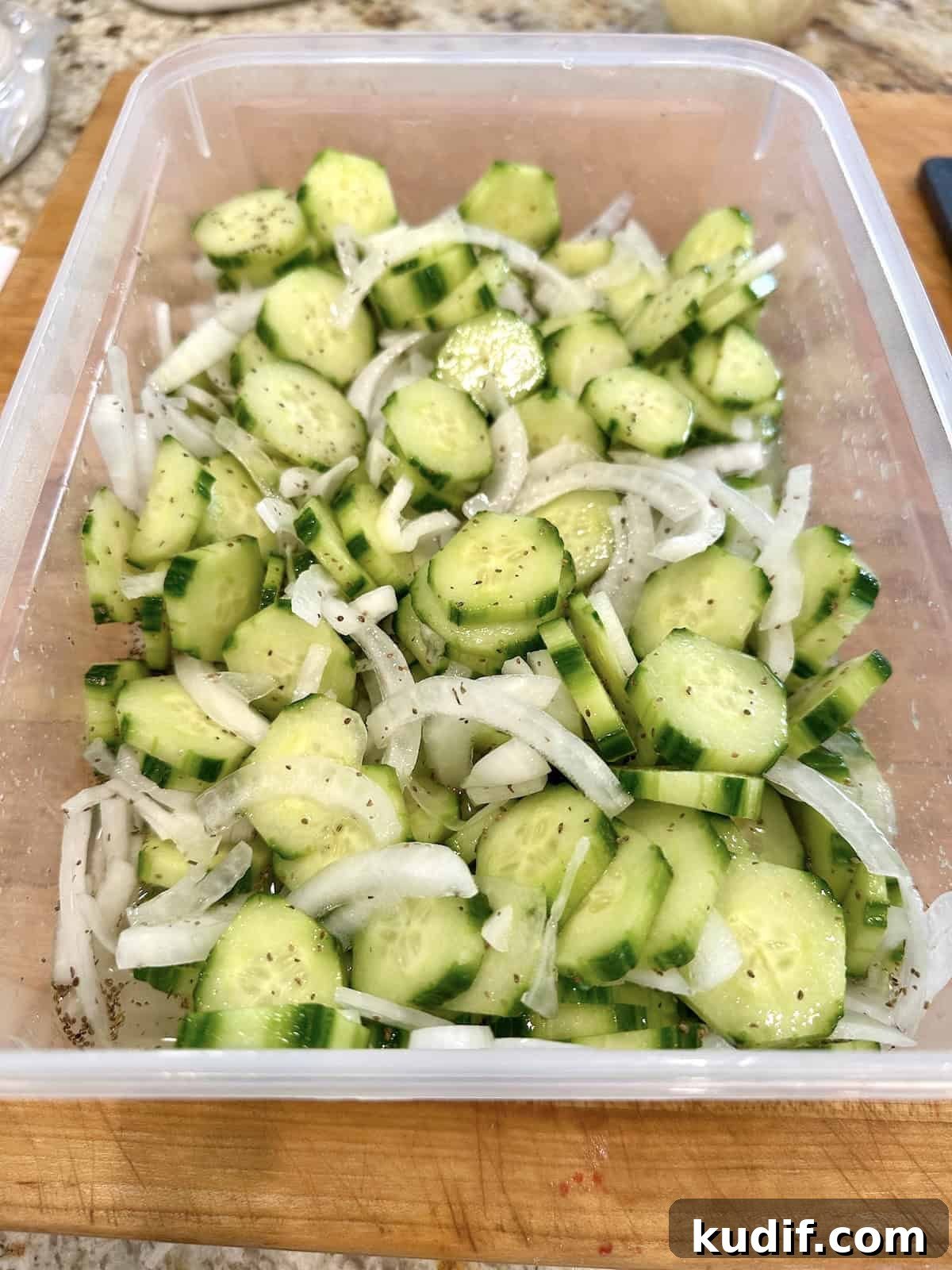 Crisp Quick Pickled Cucumbers Recipe for Homemade Snacks 10 Quick pickled cucumbers and onions in a container with brine added.