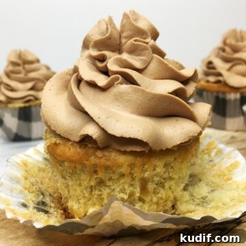 Unwrapped banana cupcake topped off with chocolate frosting.