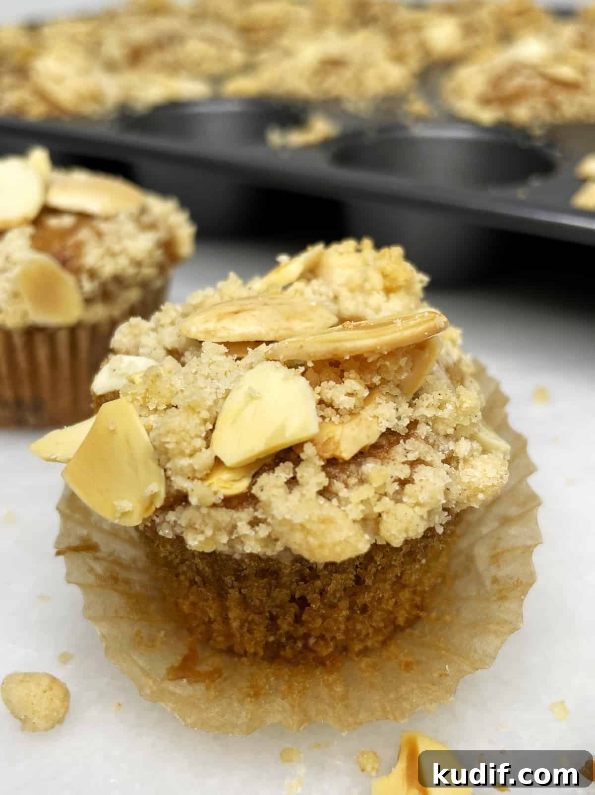 Unwrapped banana bread mini muffin with the rest of the muffins in the background