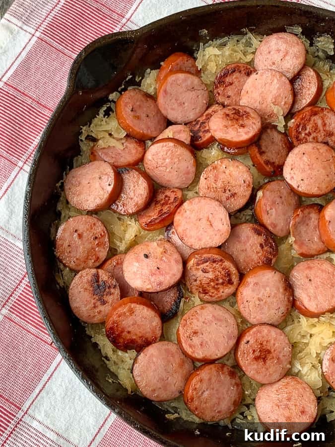 Kielbasa and Sauerkraut Recipes: Classic Polish Sausage Dishes 2 Cast iron skillet with sausage and sauerkraut on red plaid napkin.