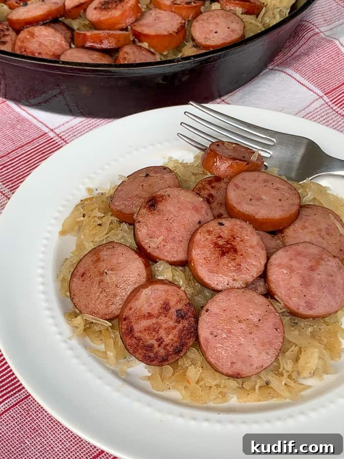 Kielbasa and Sauerkraut Recipes: Classic Polish Sausage Dishes 3 Skillet and plate of smoked sausage and sauerkraut on red plaid napkin.