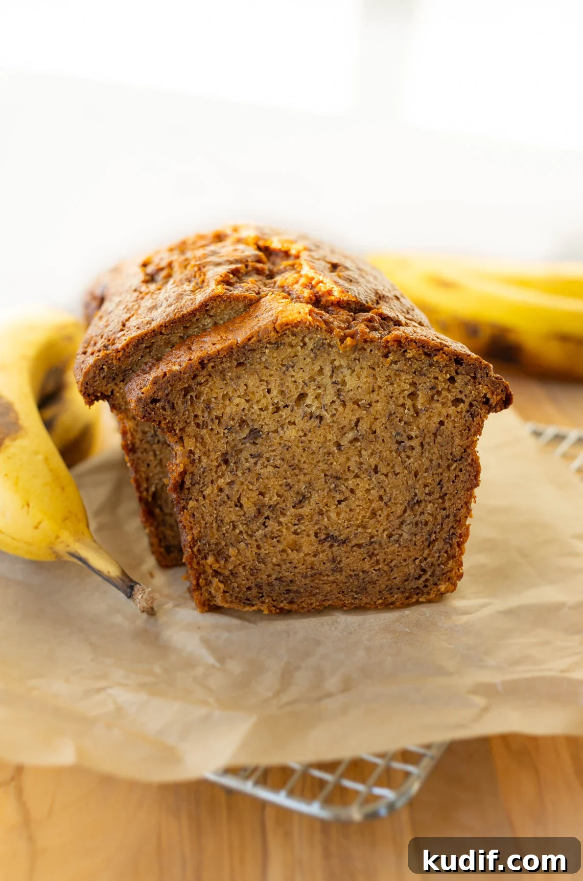 Ultimate Moist Banana Bread Recipe That Melts in Your Mouth 2 moist banana bread loaf on a cooling rack with parchment paper