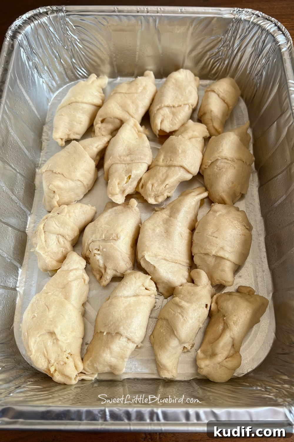 Crescent Roll Peach Dumplings with Warm Cinnamon Sauce 4 Rolled peach dumplings placed in a baking pan.
