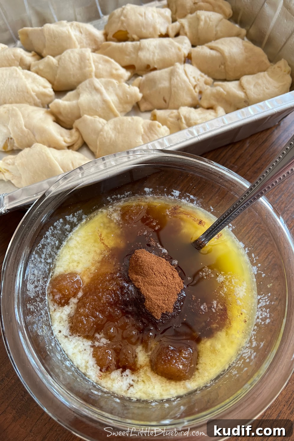 Crescent Roll Peach Dumplings with Warm Cinnamon Sauce 5 Baking pan with rolled dumplings and a bowl of cinnamon-sugar mixture in front.