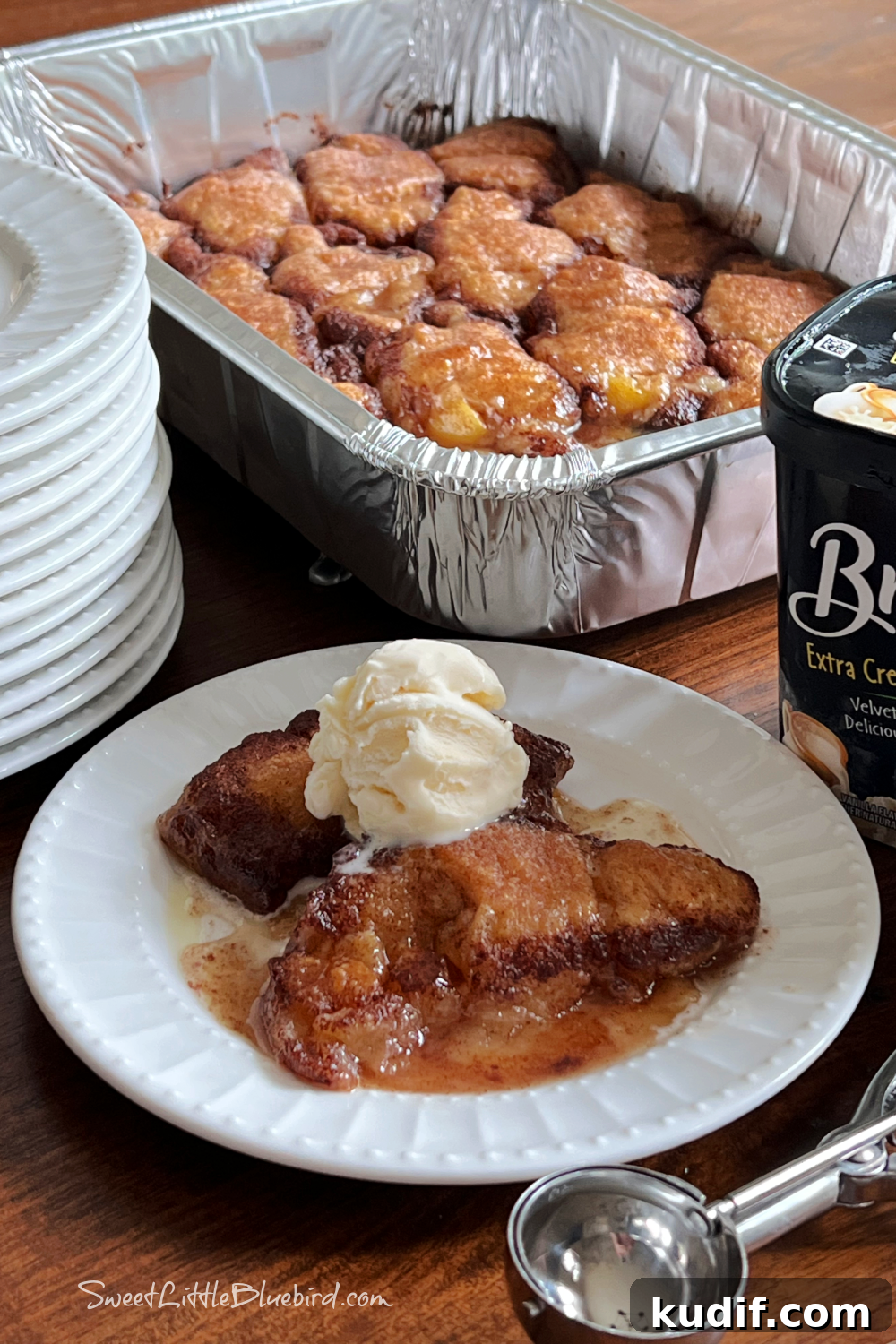Crescent Roll Peach Dumplings with Warm Cinnamon Sauce 10 Two peach dumplings on a plate with a scoop of vanilla ice cream.