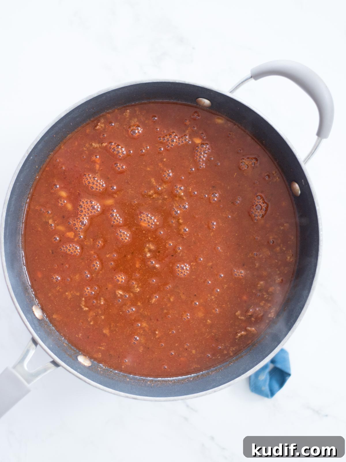 Cheesy Taco & Cream Cheese Pasta Recipe for Weeknight Dinners 6 enchilada sauce, beef broth, and tomato sauce added to skillet with ground beef