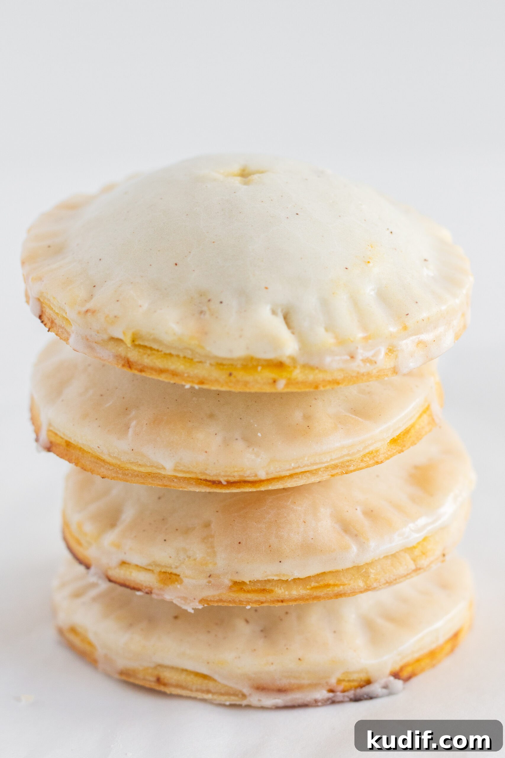 4 pumpkin hand pies stacked on top of each other.