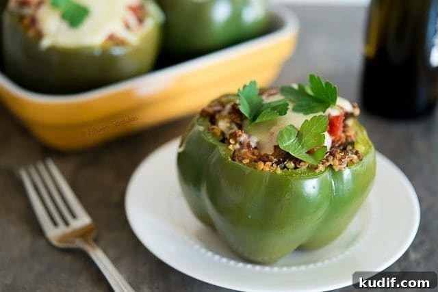 Quinoa and Eggplant Stuffed Bell Peppers with Herbs 63 Eggplant Stuffed Peppers - With One on Plate and One in Baking Dish