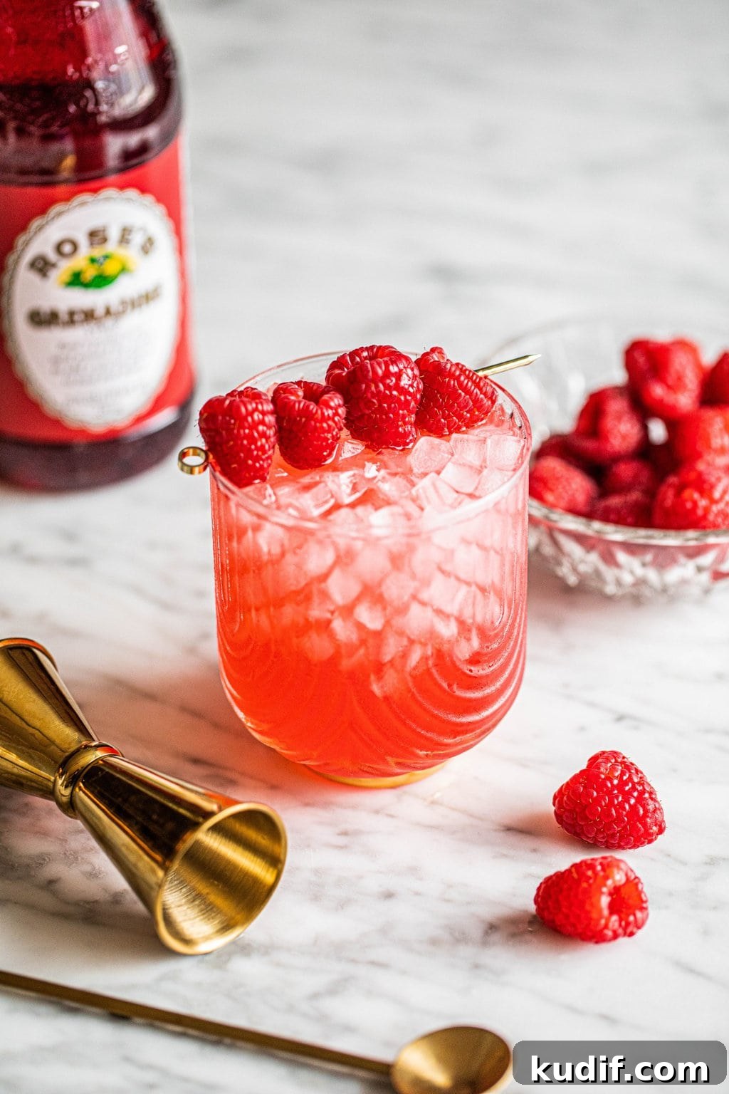 Raspberry Vodka Champagne Cocktail Recipe for Celebrations 3 champagne with vodka cocktail in glass garnished with raspberries on gold skewer
