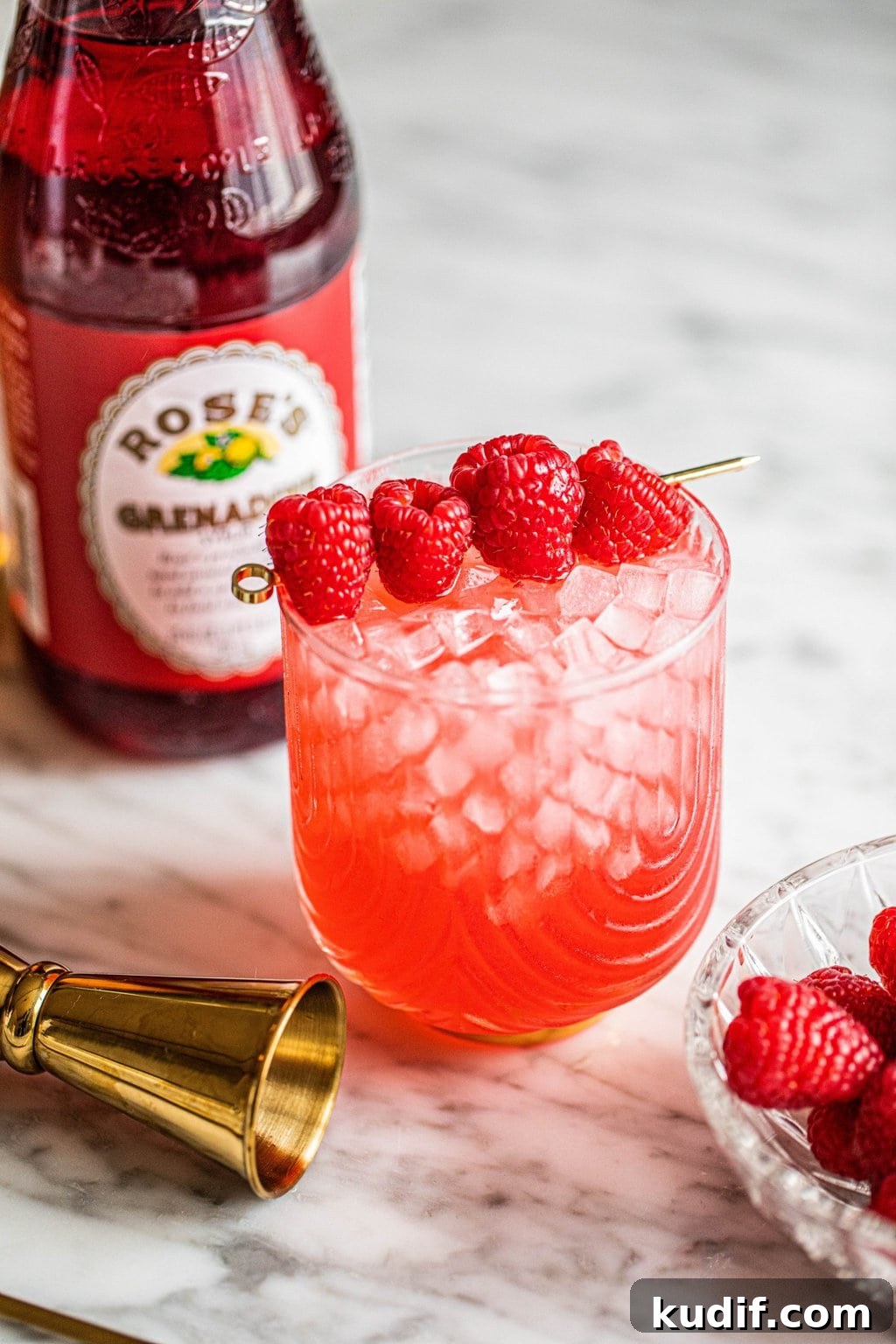 Raspberry Vodka Champagne Cocktail Recipe for Celebrations 6 champagne with vodka cocktail in glass garnished with raspberries on gold skewer
