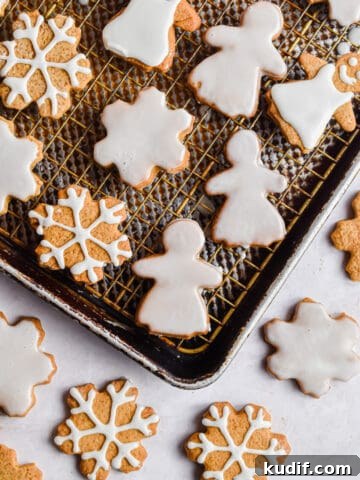 Snowflakes and gingerbread women are decorated on baking sheets.