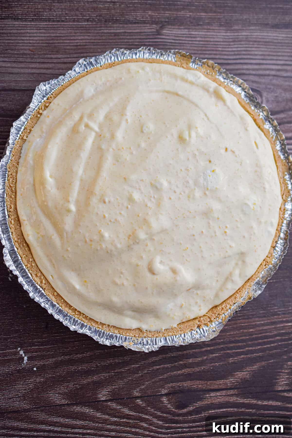 The mixture is poured into the graham cracker crust.