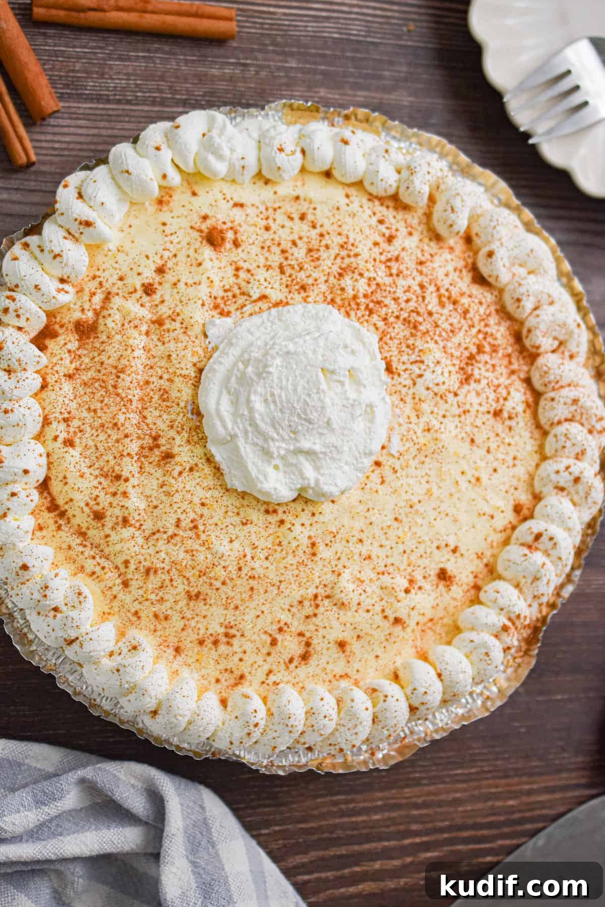 Whipped cream is decorated on top of the no-bake eggnog pie.
