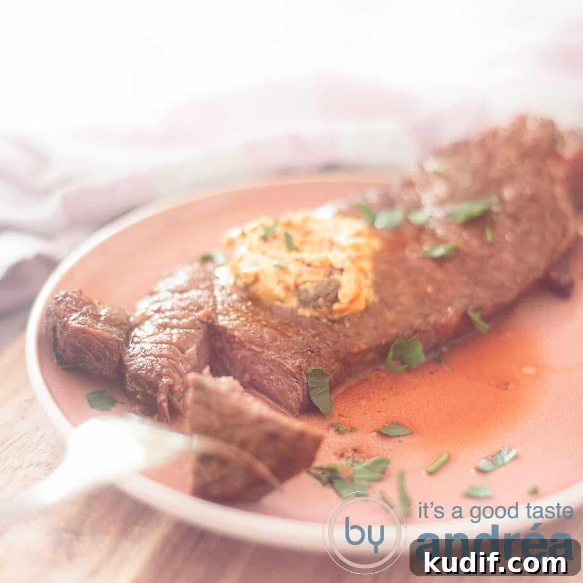 Crispy Air Fryer Sirloin Steak in 15 Minutes 7 A square photo with a piece of sirloin steak with a piece cut off on a pink plate. Herb butter melts on the sirloin steak