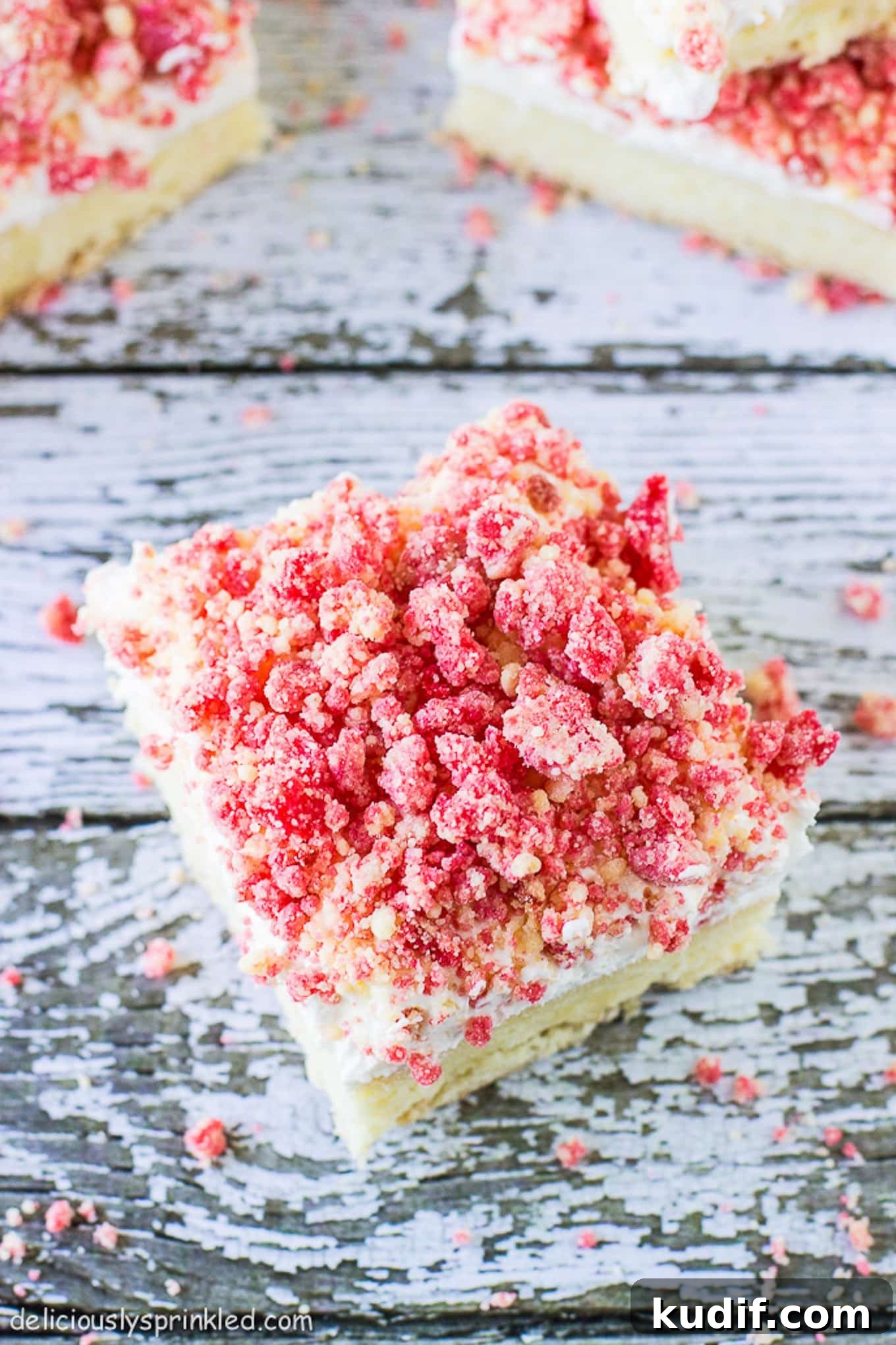 A square of strawberry crunch bars on a table ready to be eaten. 