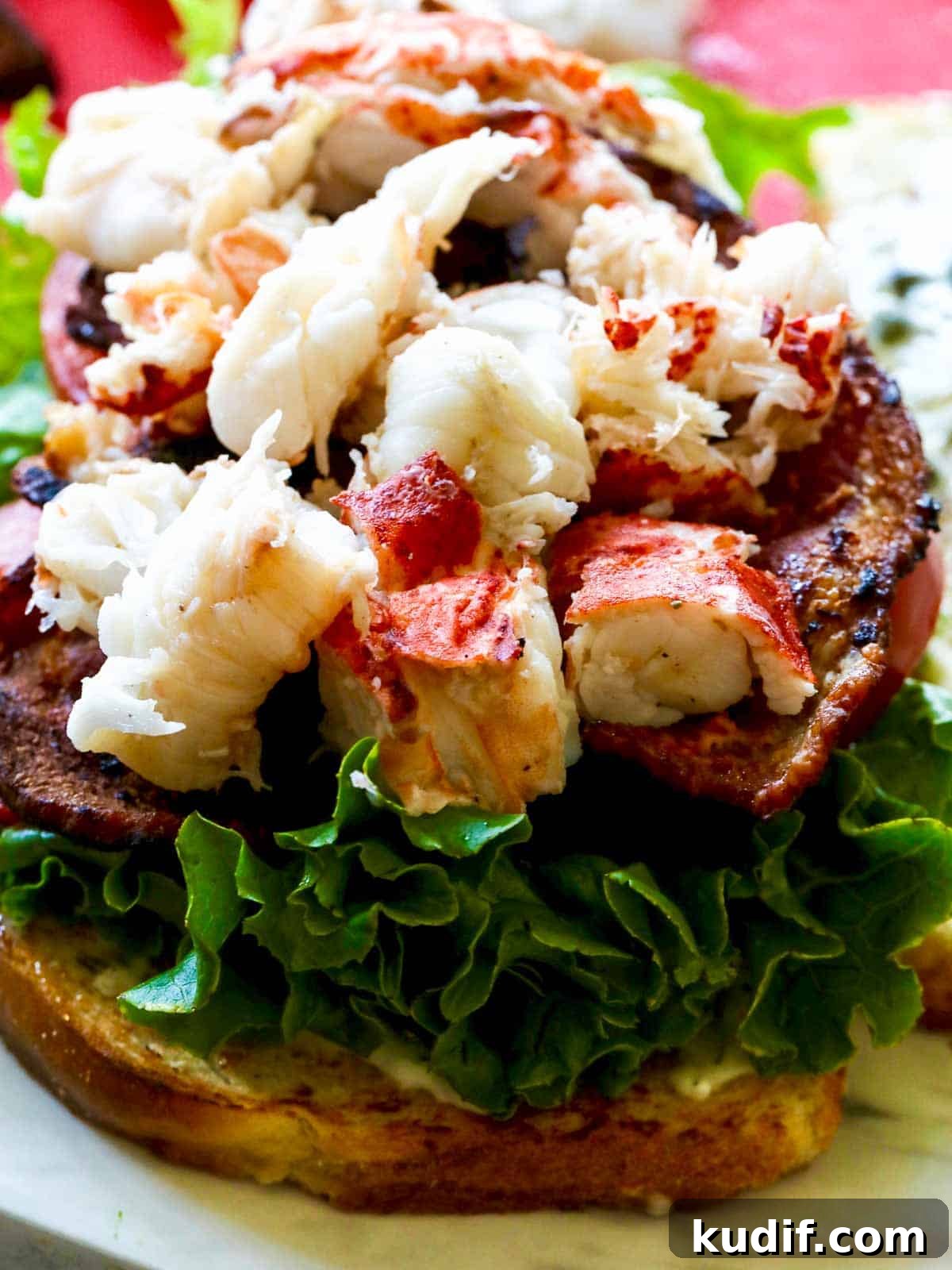 Lobster BLT Sandwich with Crispy Bacon and Lemon Aioli 11 Assembly of a lobster BLT sandwich with bread, lettuce, tomato, bacon, and lobster meat.