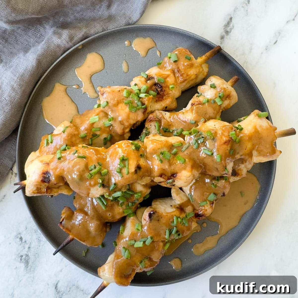 Asian Almond Butter Dipping Sauce (No-Cook) 6 Creamy almond butter Asian dipping sauce drizzled over grilled chicken skewers on a gray plate.