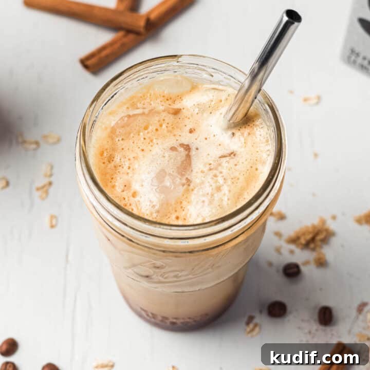 Brown sugar shaken espresso with foamy top and ice in mason jar with metal straw.