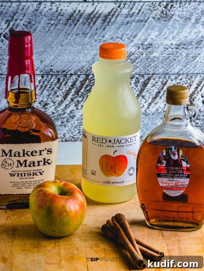Apple Cider Cocktail - sipandfeast.com #cocktails #bourbon #drinkrecipes Bottle of bourbon, maple syrup, apple, cinnamon stick and apple cider.