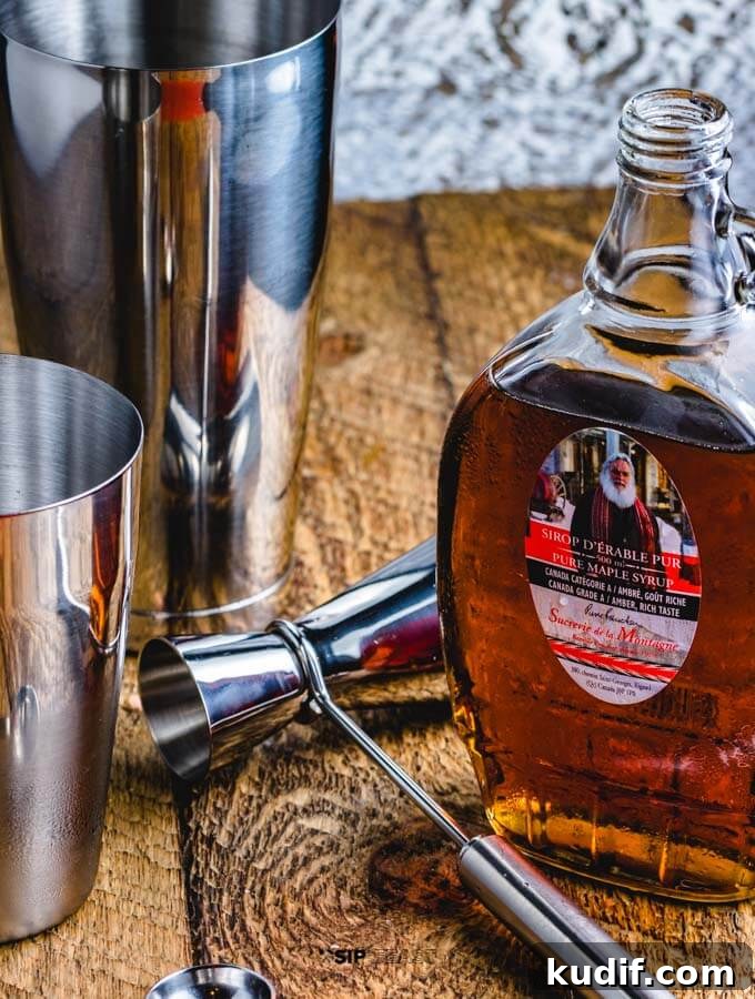 Apple Cider Cocktail - sipandfeast.com #cocktails #bourbon #drinkrecipes Cocktail shaker, cocktail jigger and maple syrup for the apple cider cocktail with maple syrup and bourbon.