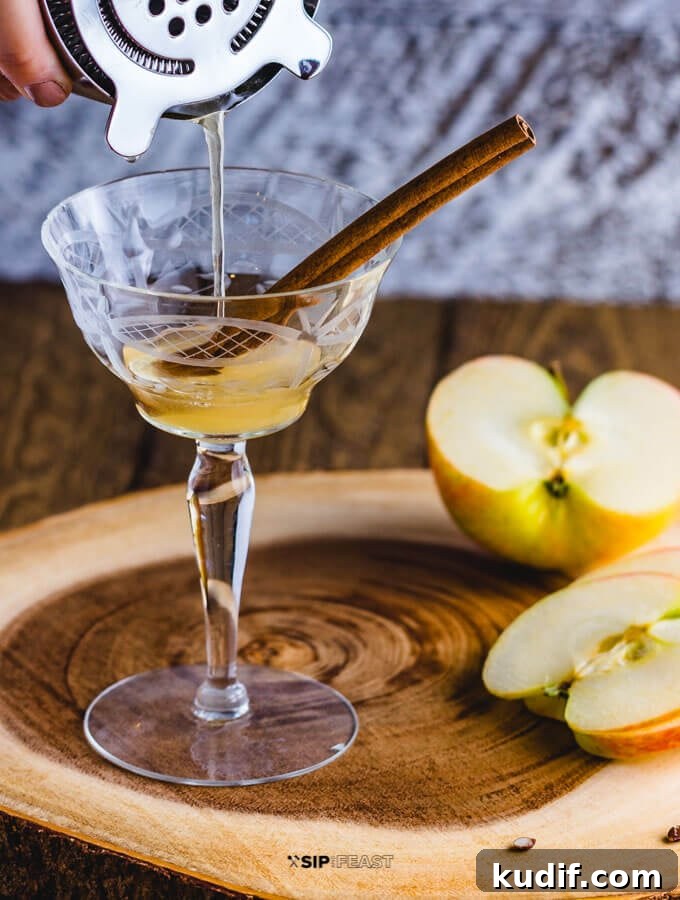 Apple Cider Cocktail - sipandfeast.com #cocktails #bourbon #drinkrecipes A cocktail shaker pouring the Apple cider cocktail with maple syrup and bourbon.