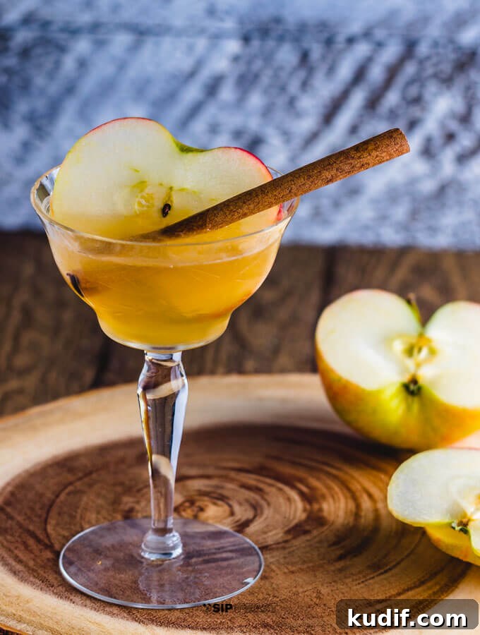 Apple Cider Cocktail - sipandfeast.com #cocktails #bourbon #drinkrecipes Apple cider cocktail with maple syrup and bourbon in a glass with apple and cinnamon.