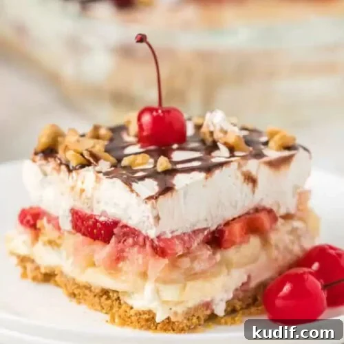 Irresistible Banana Dessert Recipes You’ll Love 6 Banana Split Cake sliced on a plate and topped with a cherry.