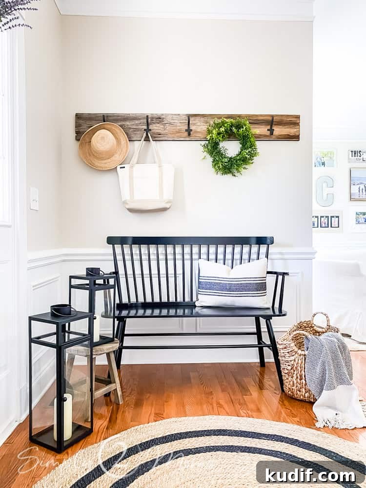 foyer makeover with round area run on hardwood floors and lanterns and basket on floor beside bench with throw pillow row of hooks on wall above bench with hat, tote bag and wreath hanging on hooks
