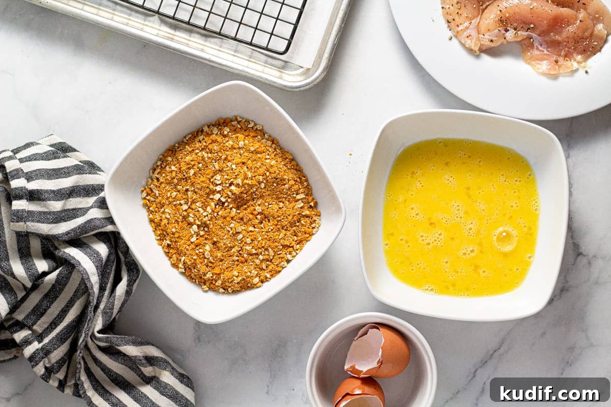 Overhead shot of two bowls on filled with breading mixture and one filled with beaten eggs 