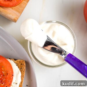Creamy Tofu Vegan Mayonnaise Recipe — Quick & Luscious 11 Vegan mayo in a glass jar. Purple spreader plus bright red tomatoes surround it.