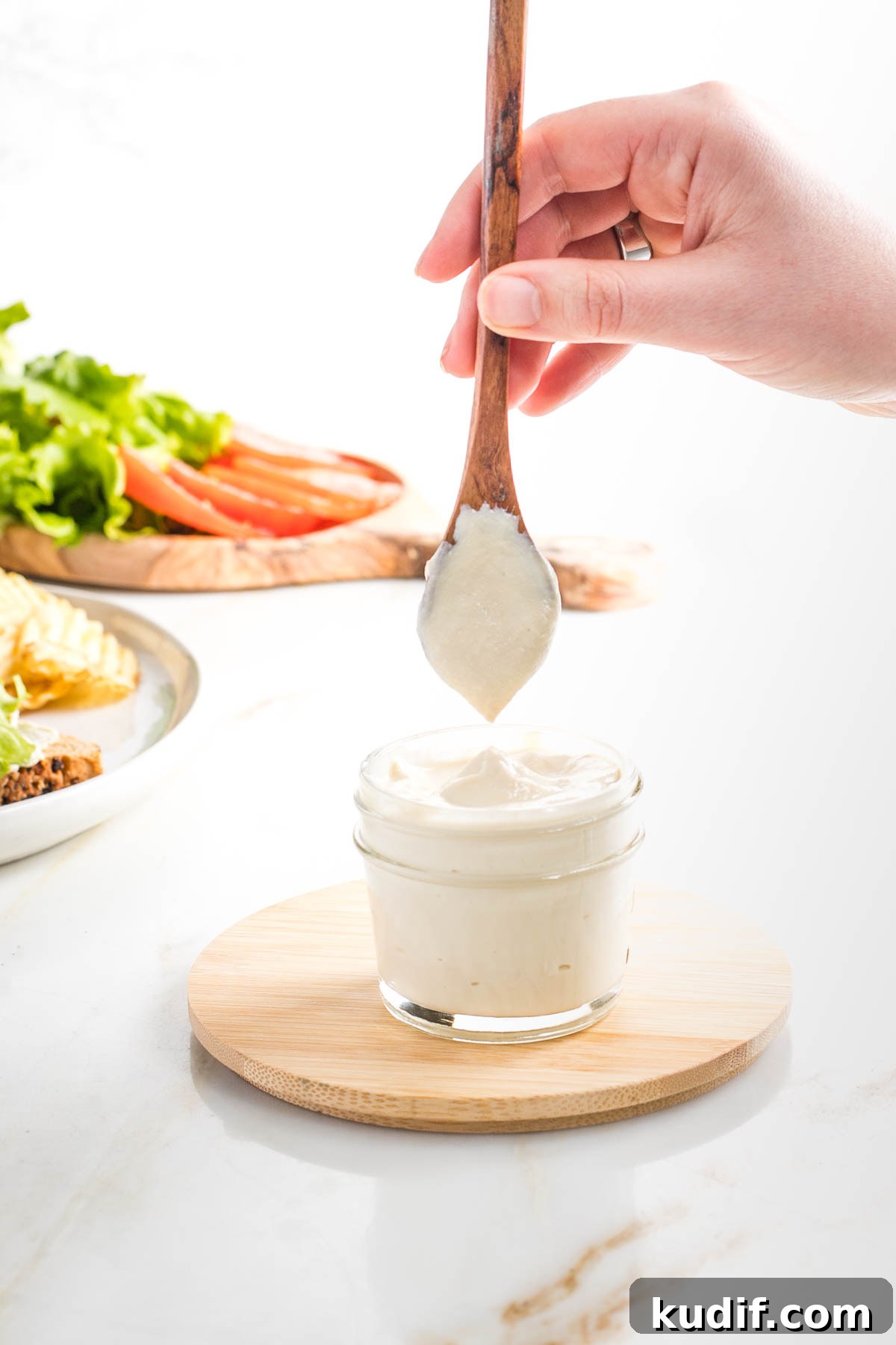 Creamy Tofu Vegan Mayonnaise Recipe — Quick & Luscious 3 Spoon showing how thick and creamy vegan mayonnaise is in a small glass mason jar.