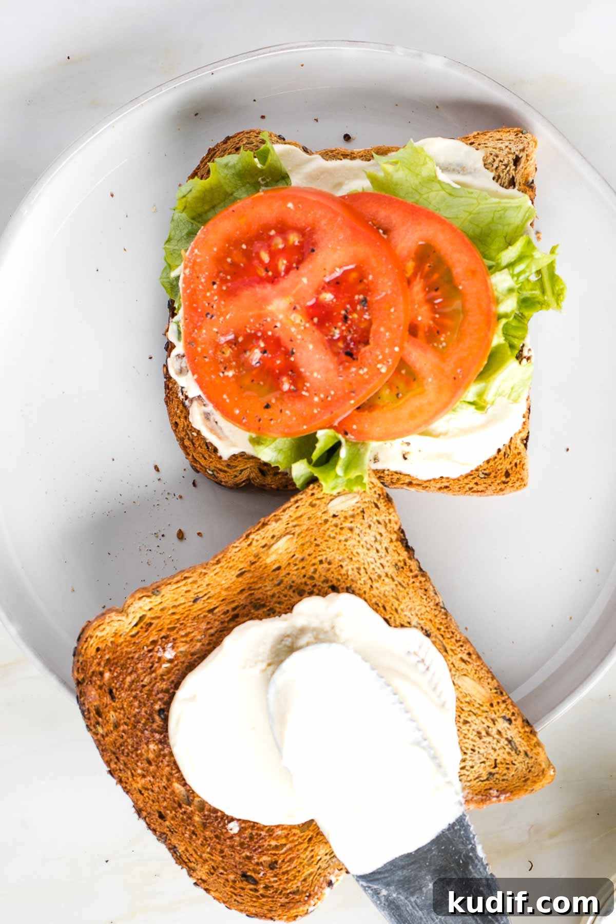 Creamy Tofu Vegan Mayonnaise Recipe — Quick & Luscious 10 Vegan Mayo slathered on thick to a piece of toast, the other side has lettuce tomato slices and more mayonnaise.