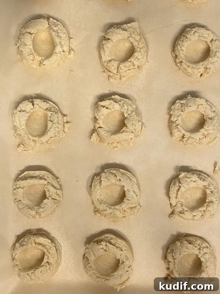 Raspberry Jam Thumbprint Cookies Recipe for Soft, Buttery Cookies 14 several pre-baked cookies with imprint on baking sheet