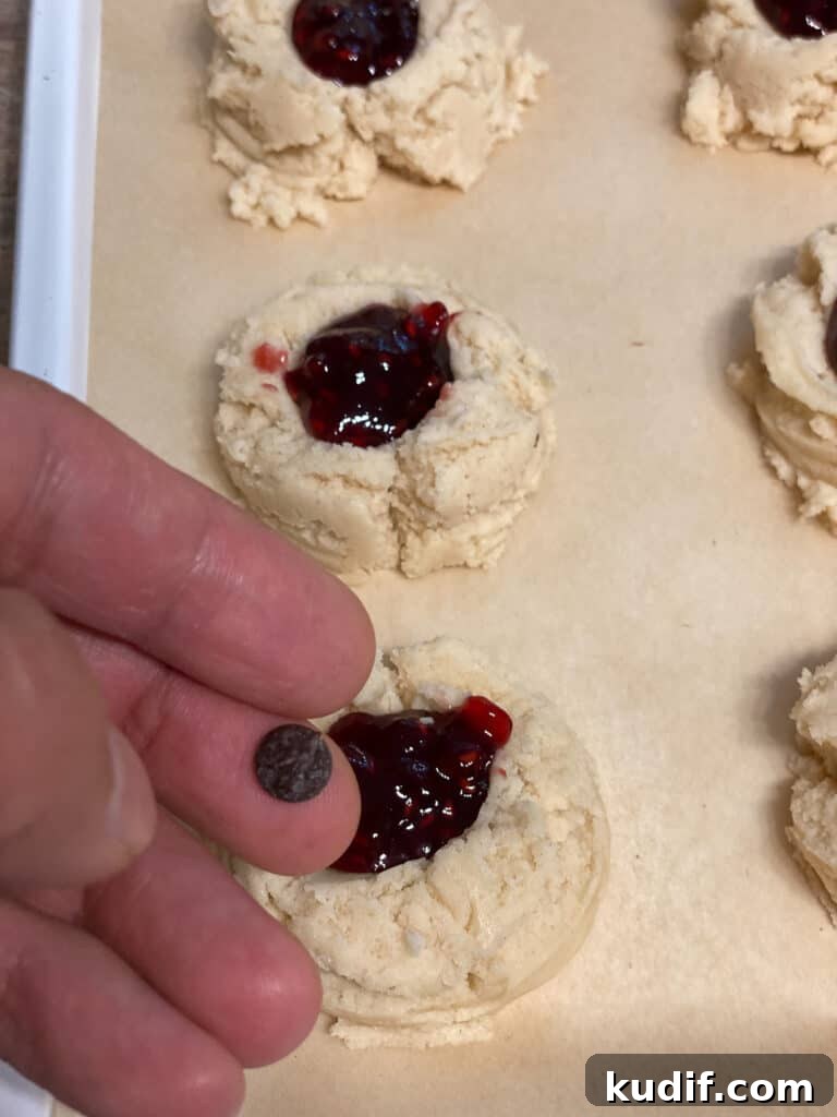Raspberry Jam Thumbprint Cookies Recipe for Soft, Buttery Cookies 16 process shot of adding chocolate chips to cookies